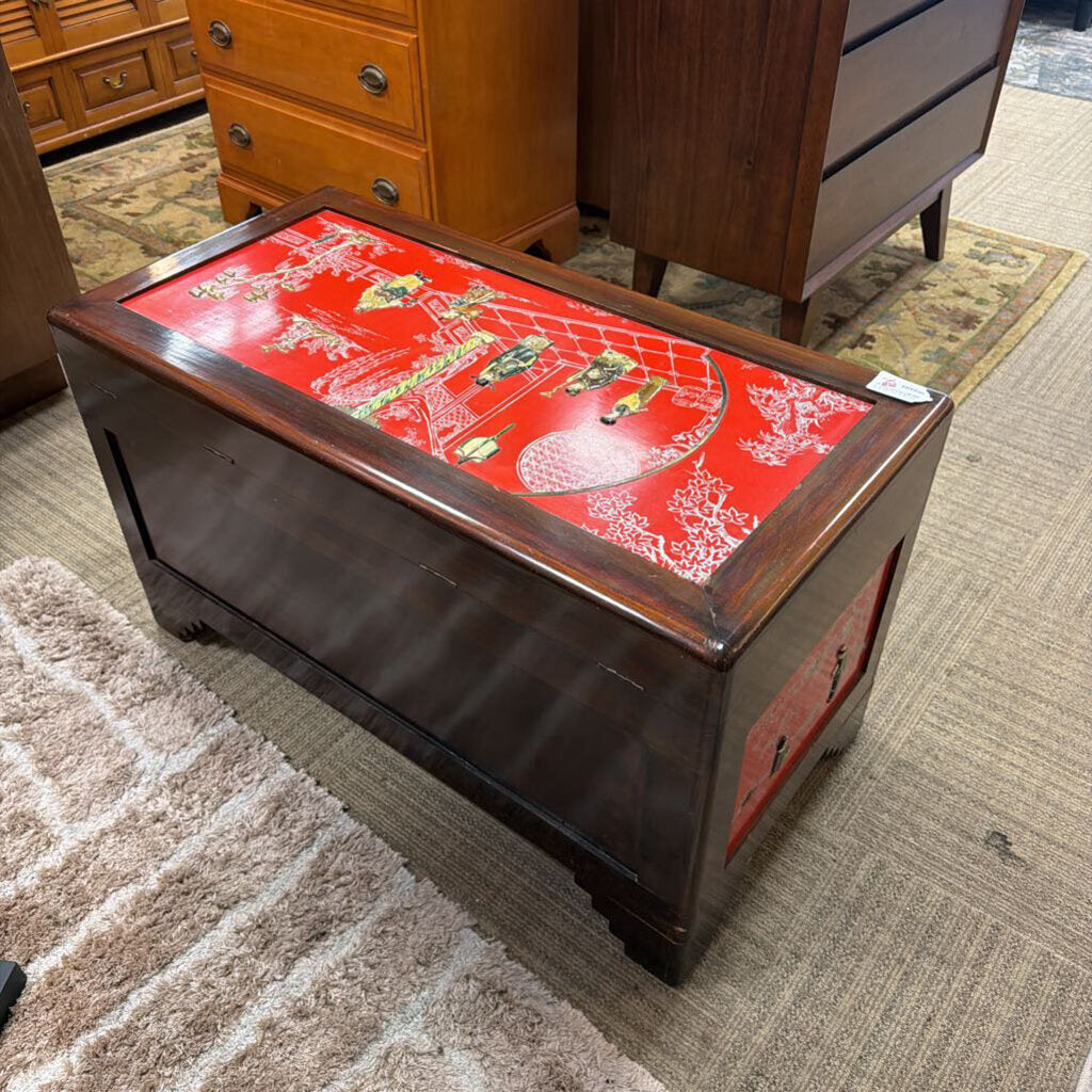 Wooden coffee table with a red decorative top in a room with furniture.