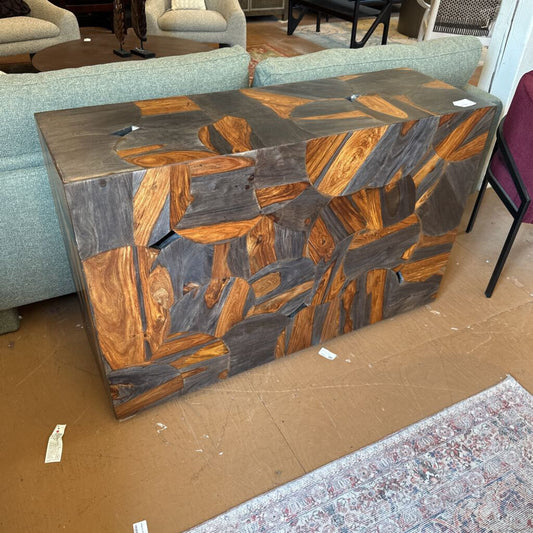 Wooden console table with a geometric pattern on a cardboard surface, surrounded by furniture.