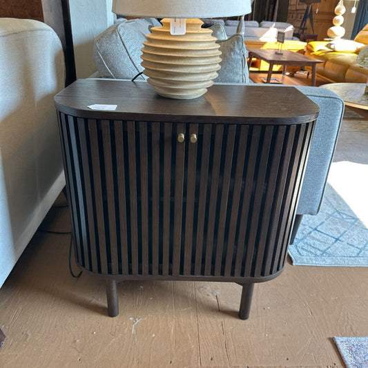 Wooden side table with a lamp in a living room setting