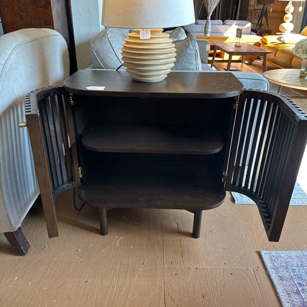 Dark wooden side table with open doors in a living room setting