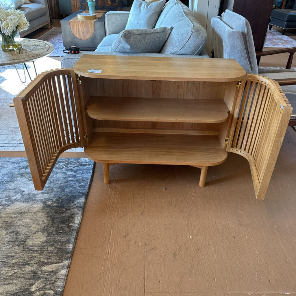 Wooden sideboard in a living room setting with a sofa and coffee table.