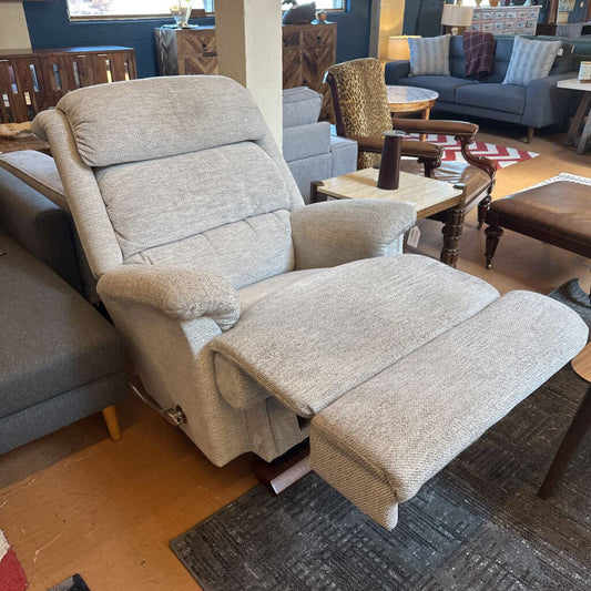 Gray recliner chair with ottoman in a furniture store setting