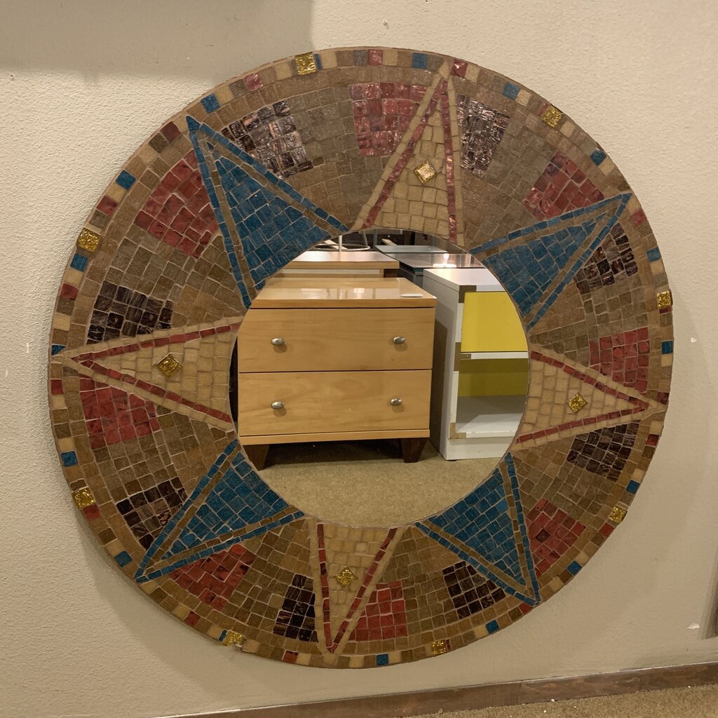 Round mosaic mirror with geometric design on a wall