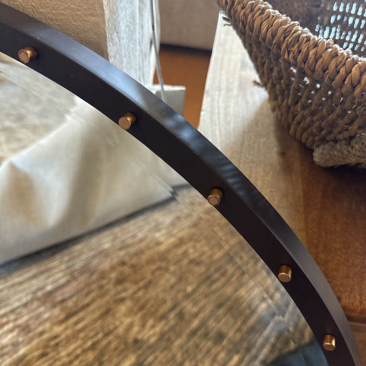 Close-up of a chair arm with a woven backrest and wooden seat.