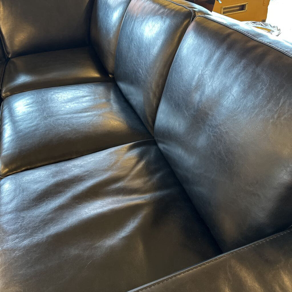 Brown leather sectional sofa with visible wear and tear.