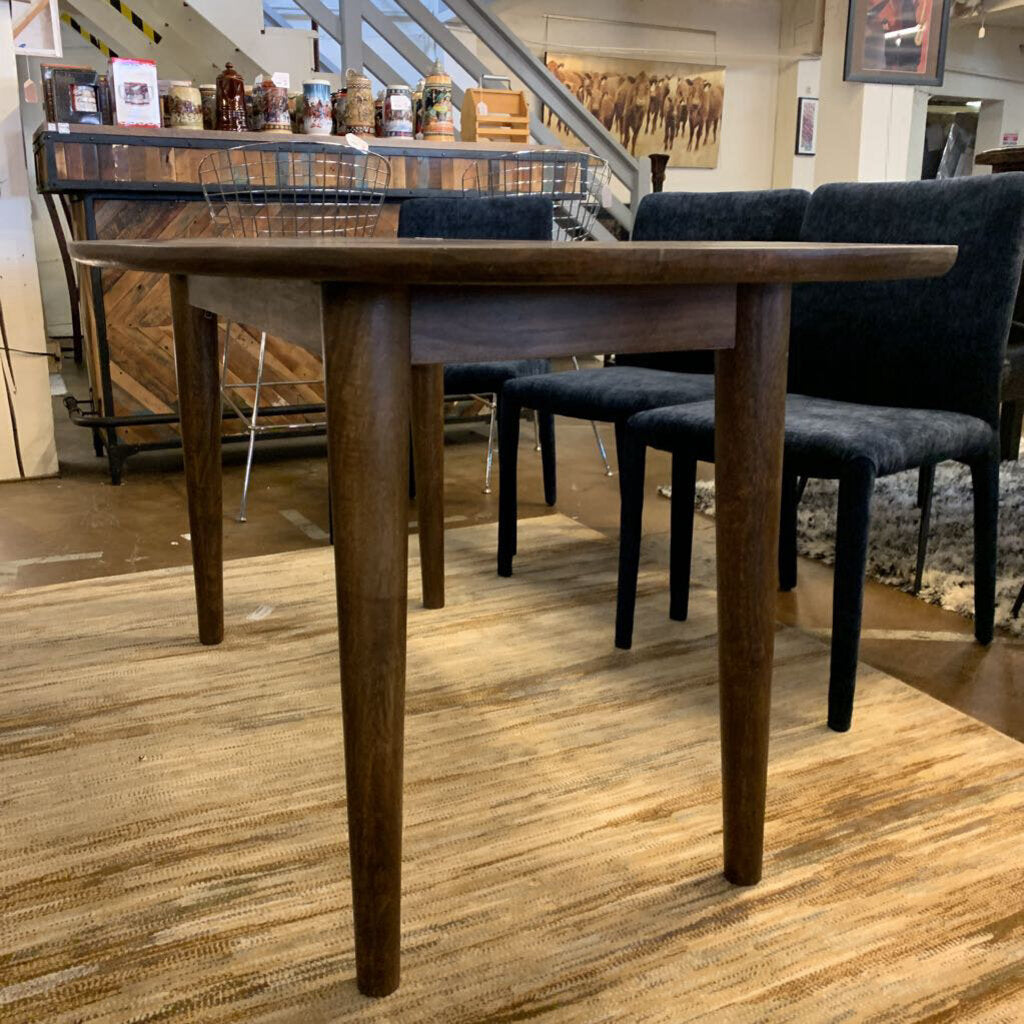 Wooden dining table with chairs in a showroom setting