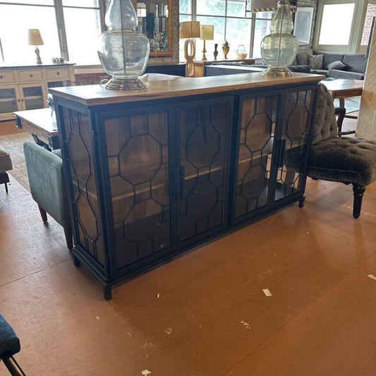 Blue cabinet with decorative glass doors in a room with furniture and decor.