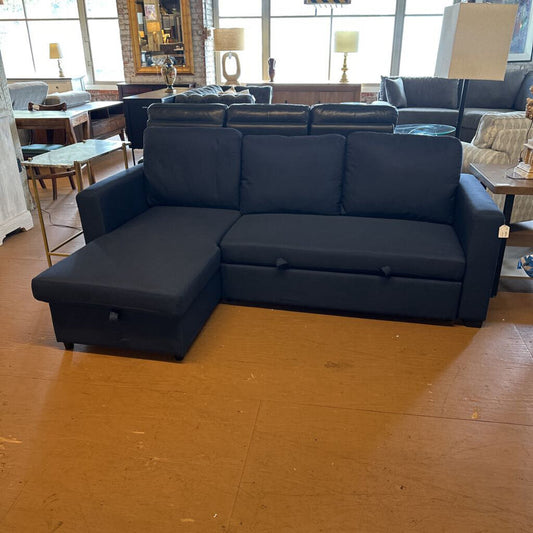 Blue sectional sofa in a showroom setting with wooden flooring.