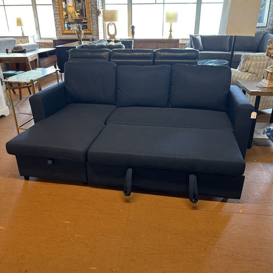 Blue sectional sofa in a room with tables and chairs.