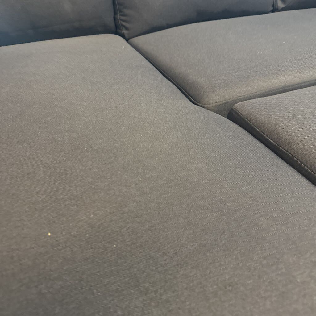Gray sectional sofa with a textured fabric finish.