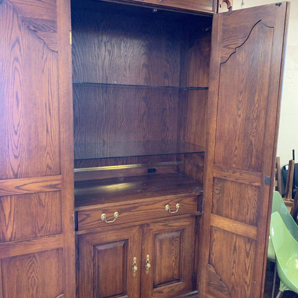 Wooden cabinet with open doors showing shelves and drawers.