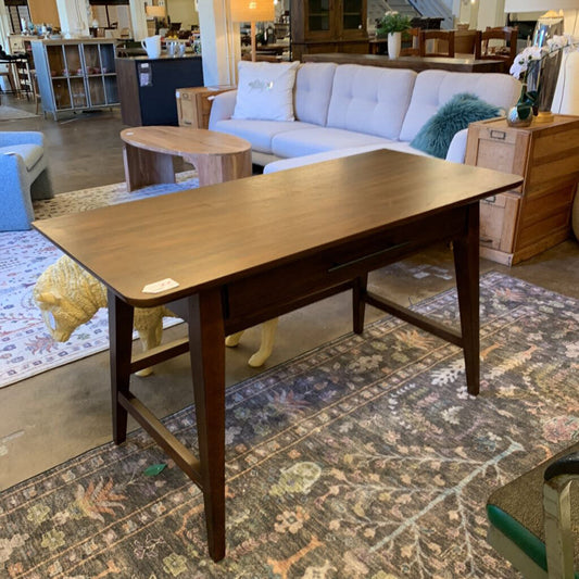 Wooden coffee table in a living room setting with a sofa and rug.