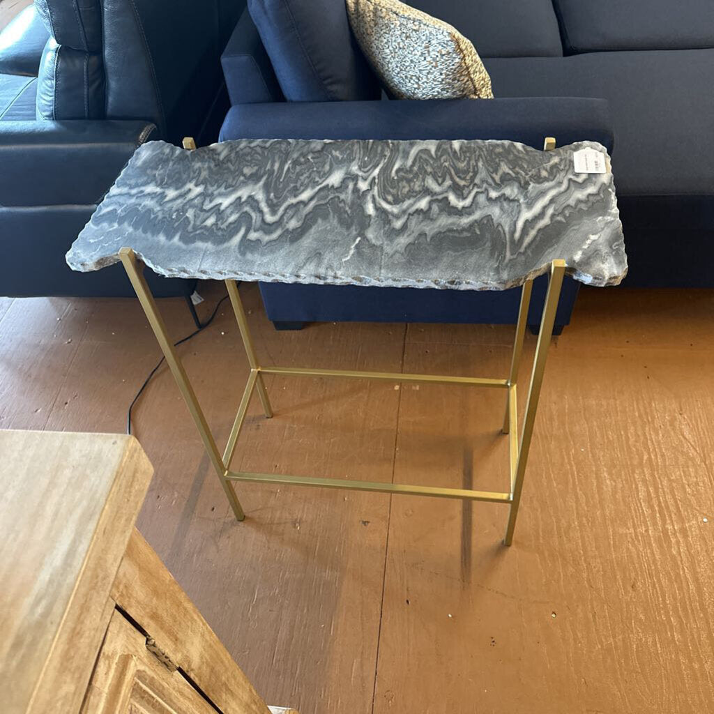 Small side table with marble top and gold frame in a living room setting.
