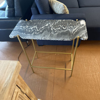Small side table with marble top and gold frame in a living room setting.