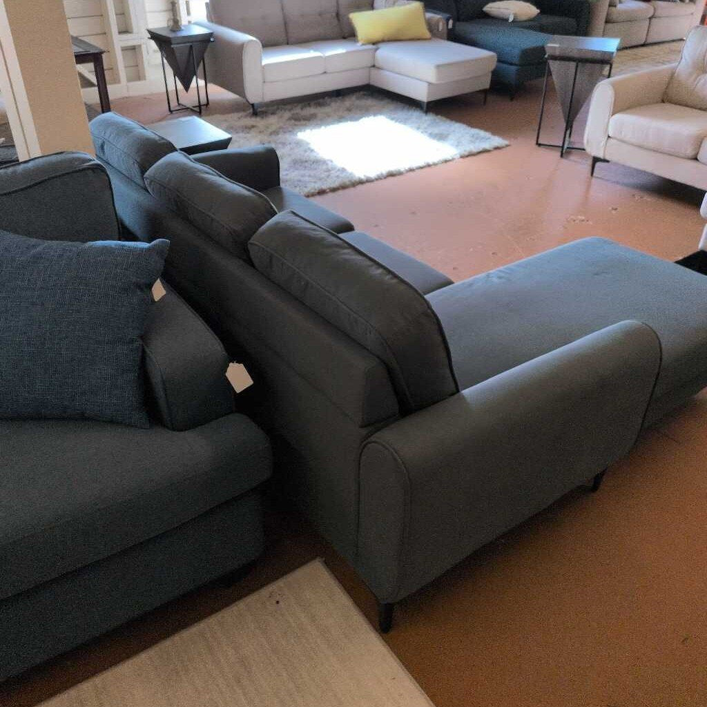 Gray sectional sofa in a living room setting with other furniture.