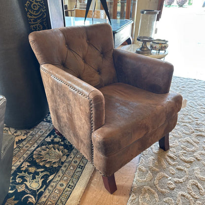 Brown leather armchair on a patterned rug with a decorative rug in the background