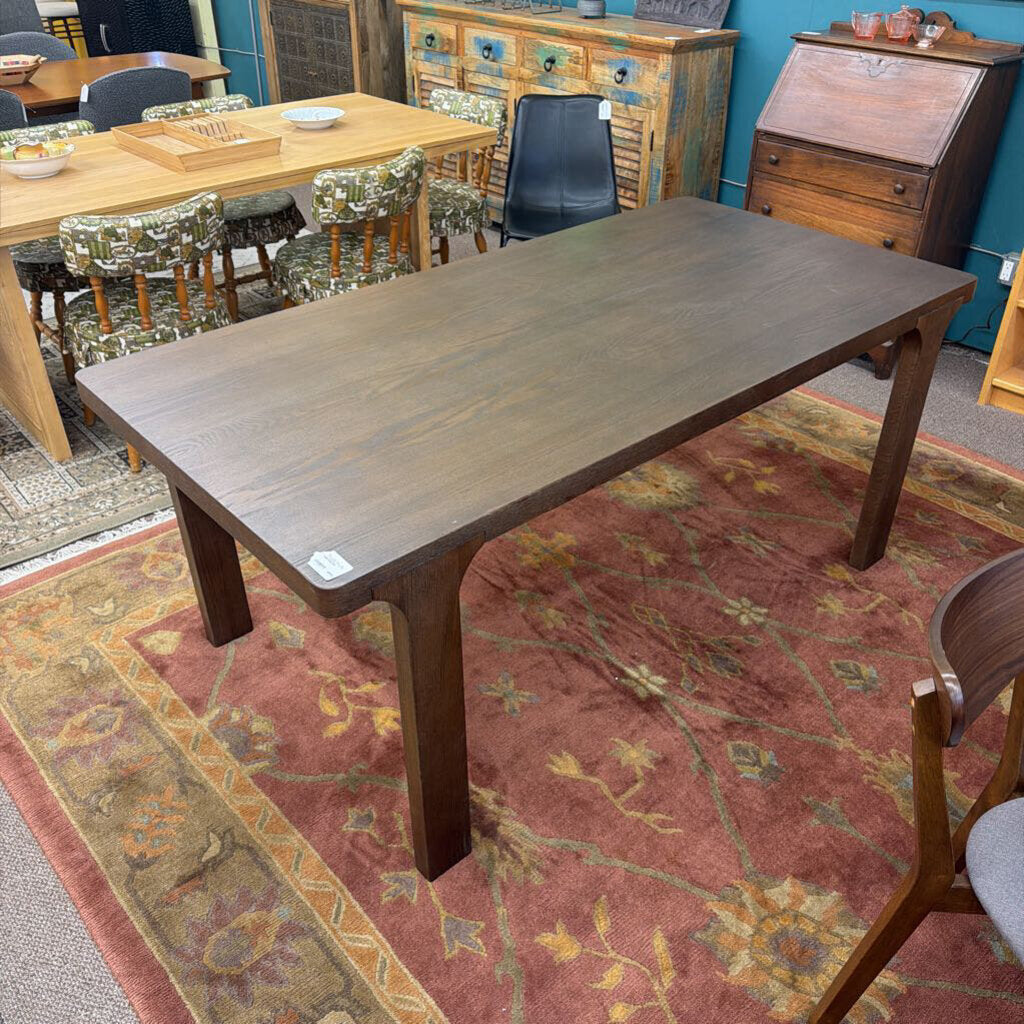 Wooden dining table in a room with chairs and a rug