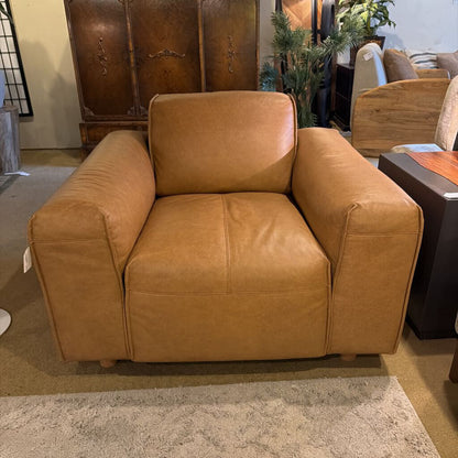 Brown leather armchair in a room with other furniture.