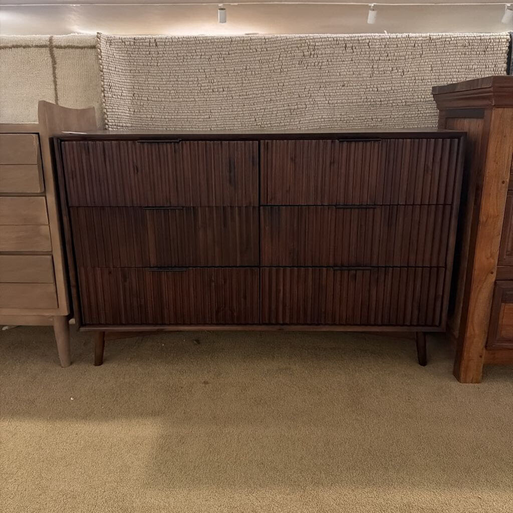 Wooden dresser with a textured wall in the background