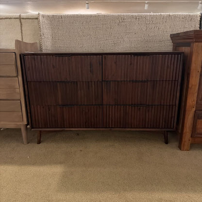 Wooden dresser with a textured wall in the background