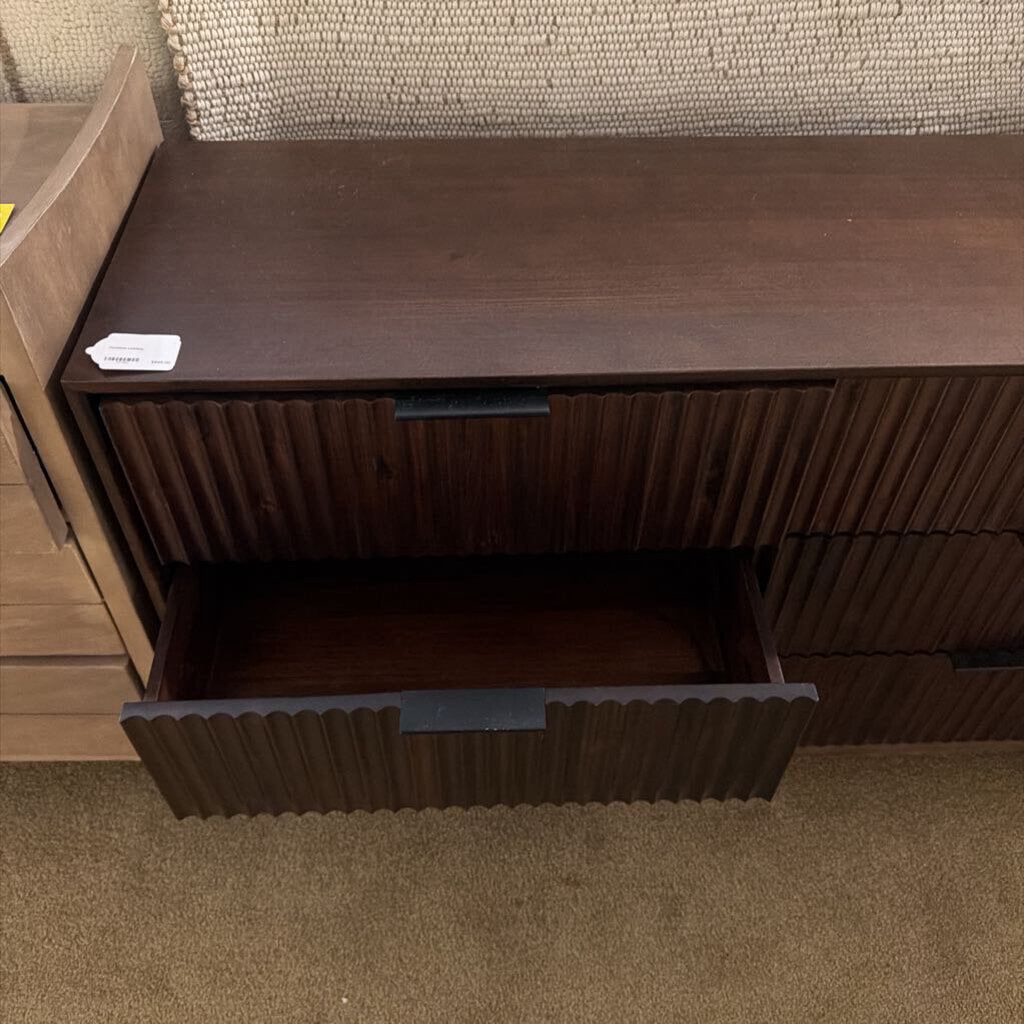 Wooden dresser with open drawer in a room setting