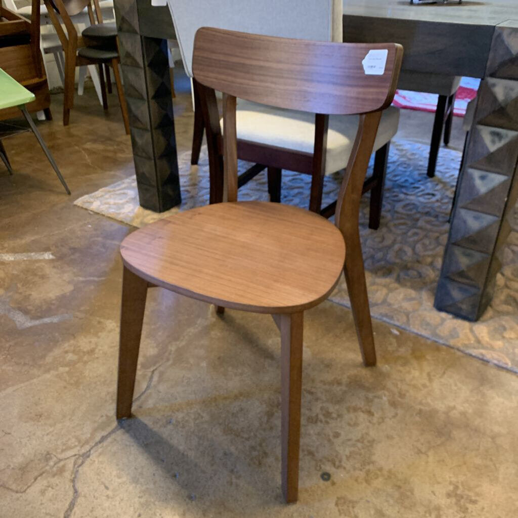 Wooden chair with a brown seat and backrest on a stone floor.
