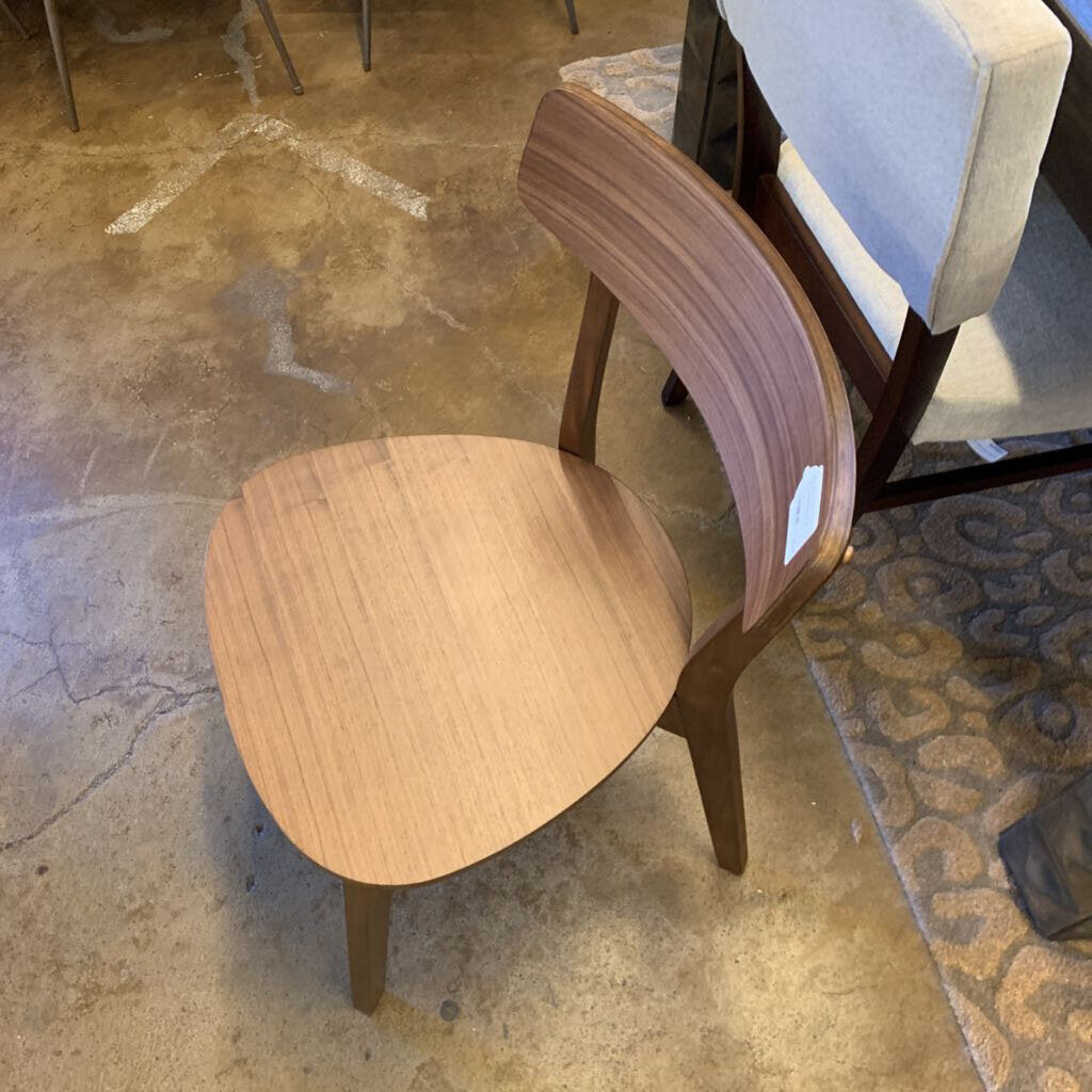 Wooden chair with a brown seat and backrest on a concrete floor.