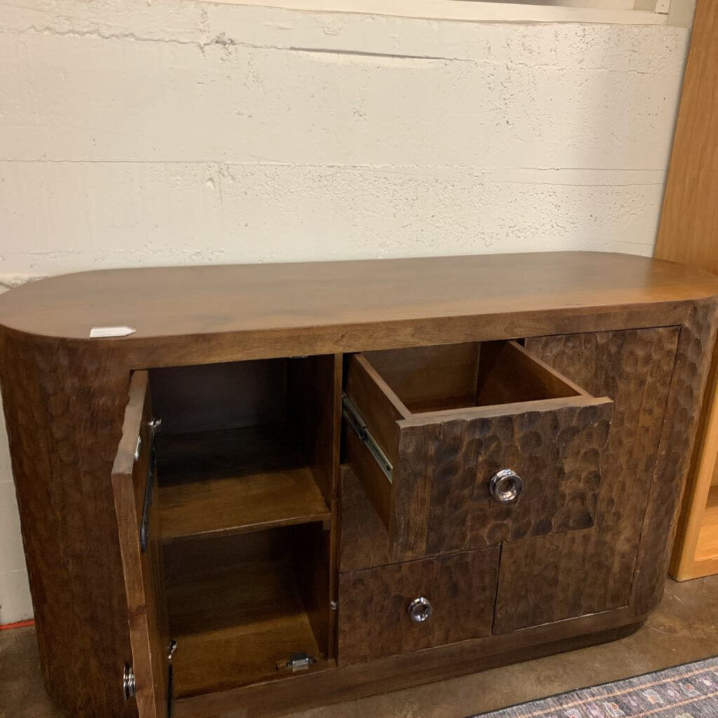 Wooden console table with open drawer against a textured wall.