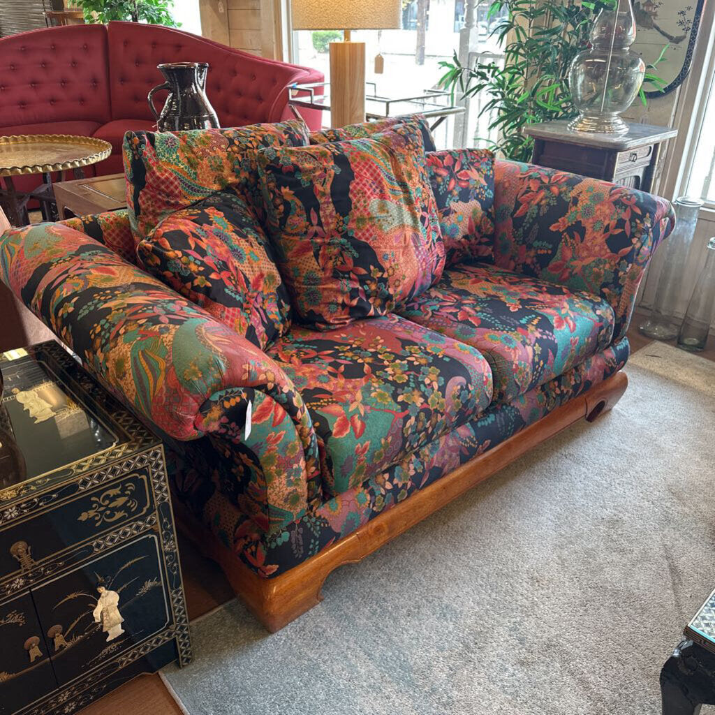 Colorful patterned sofa in a living room setting with a black side table.