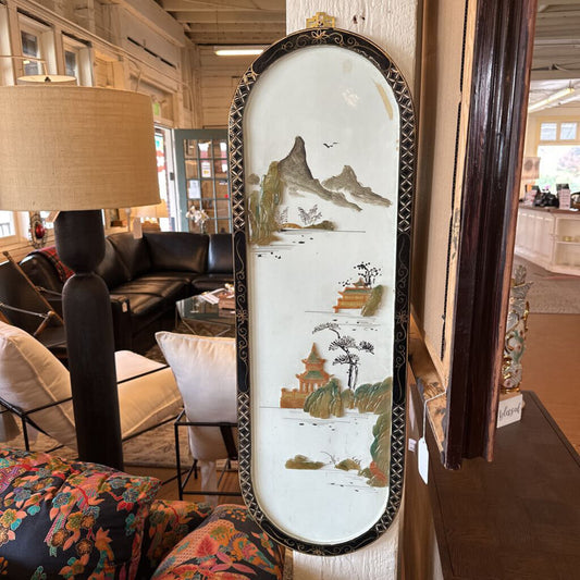Decorative mirror with a scenic design in a living room setting