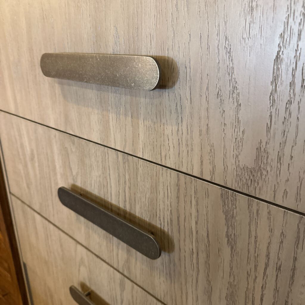 Wooden cabinet with two handles on a light wood background