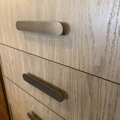 Wooden cabinet with two handles on a light wood background