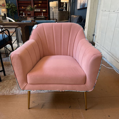 Pink armchair with gold legs in a room setting