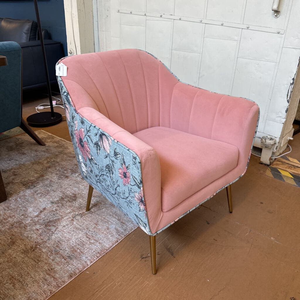 Pink chair with floral armrests in a room setting