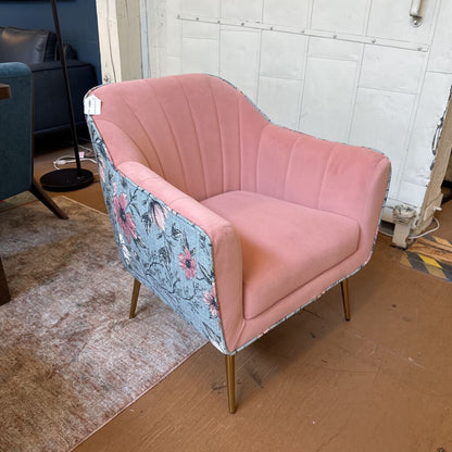 Pink chair with floral armrests in a room setting