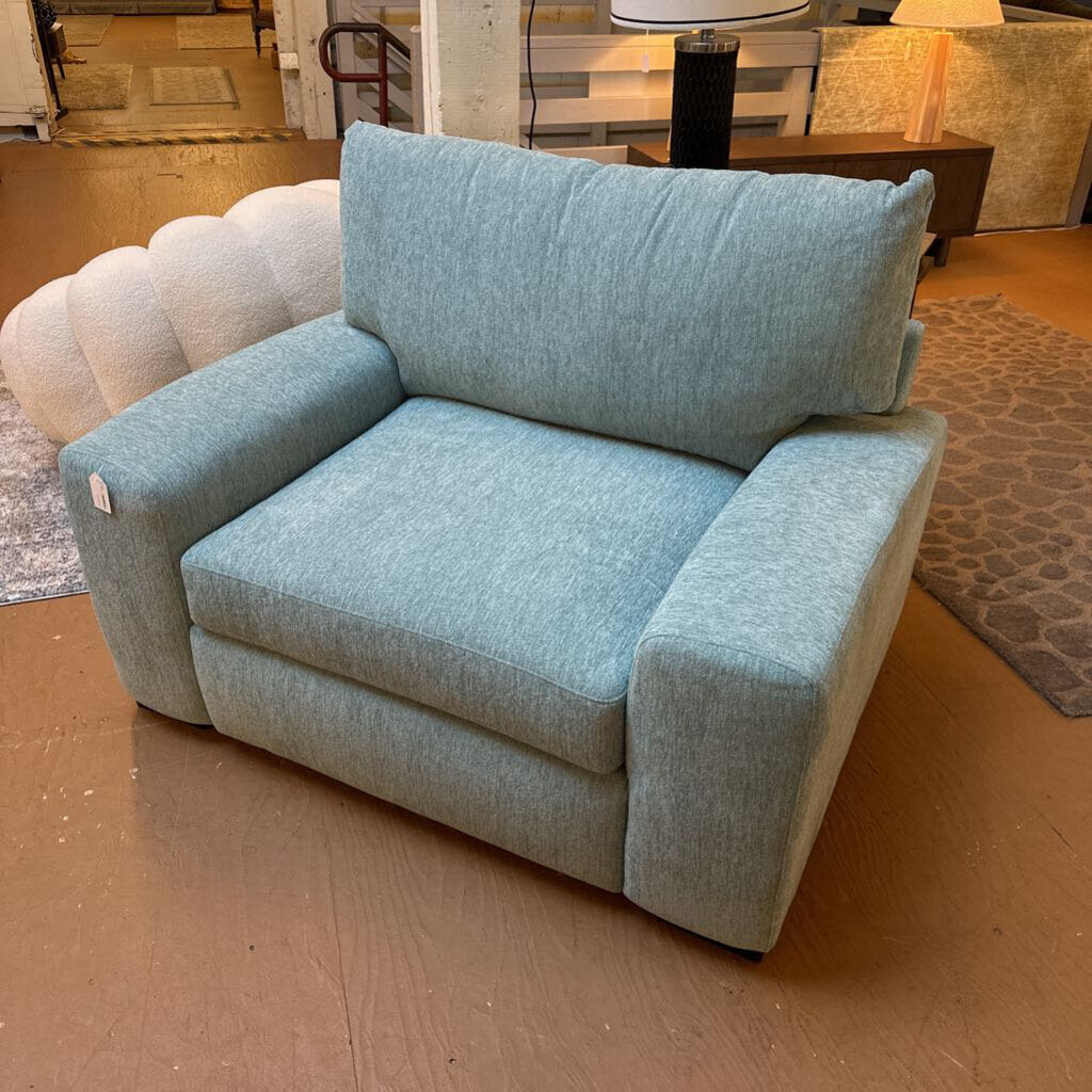 Light blue armchair on a wooden floor with a blurred background