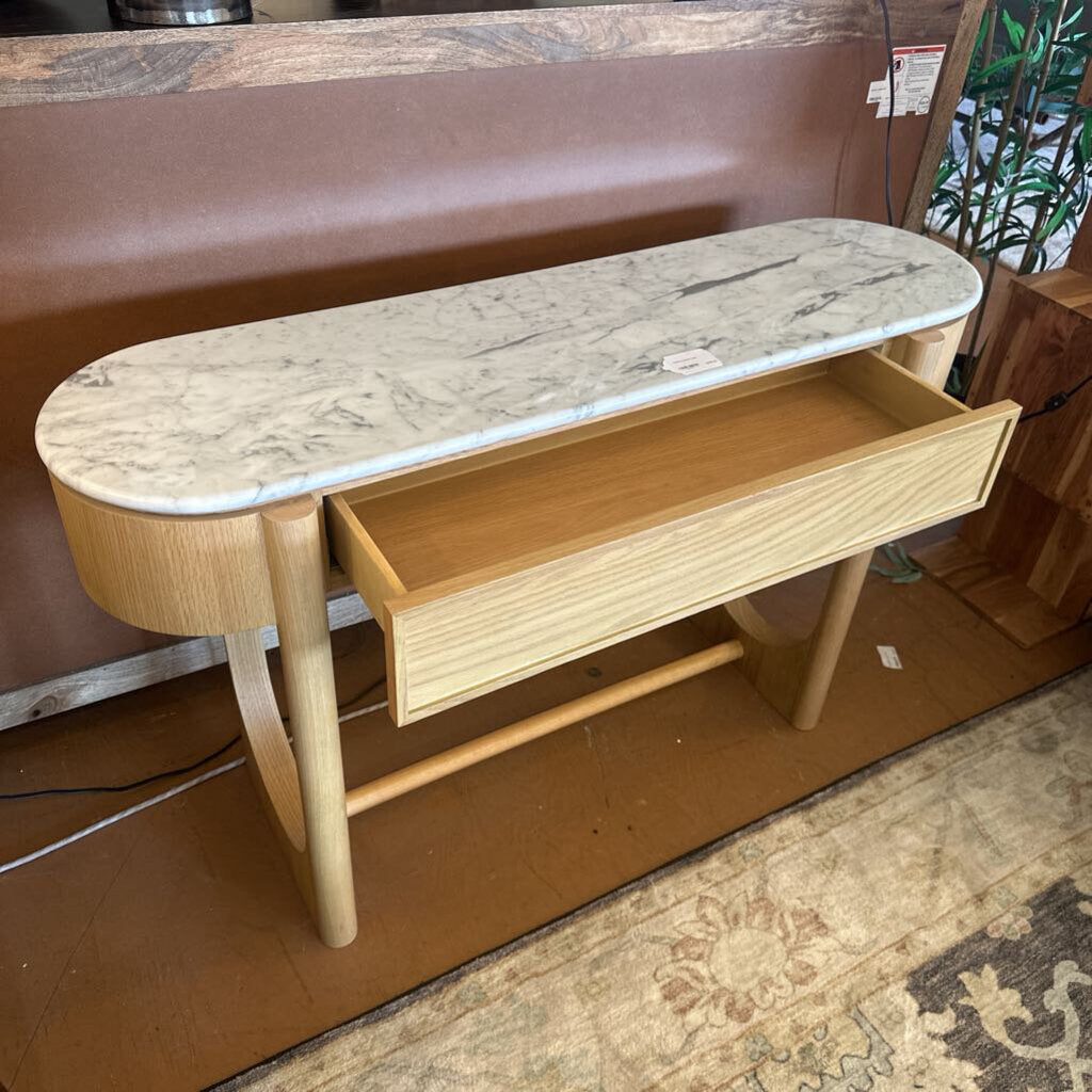 Wooden console table with marble top and drawer in a room setting