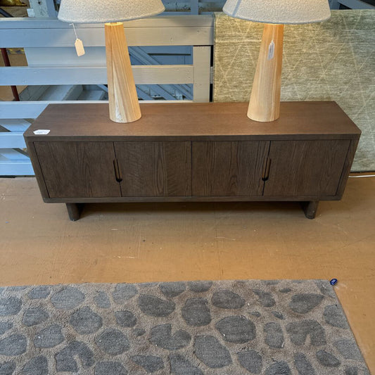 Wooden sideboard with two lamps on top in a store setting