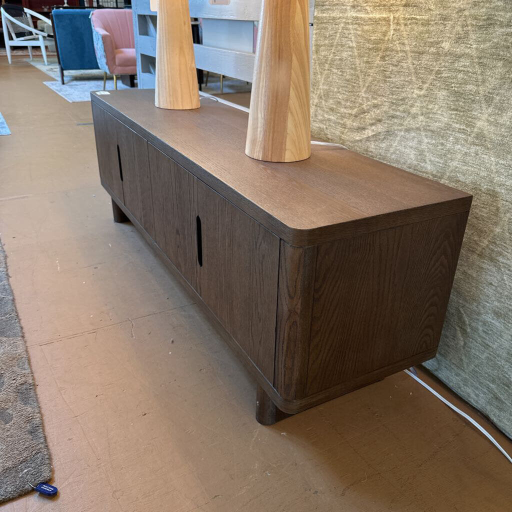 Wooden console table in a room with chairs and a rug.
