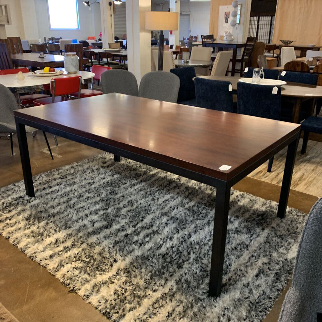 Wooden dining table in a room with chairs and tables