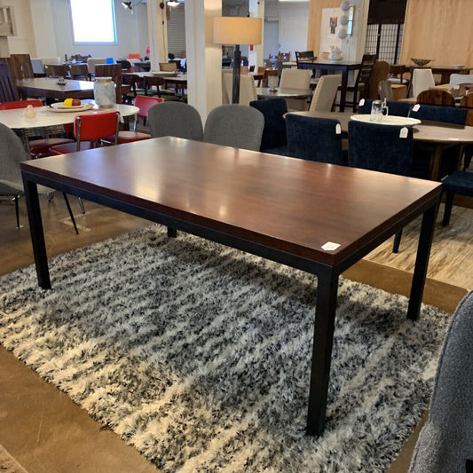 Wooden dining table in a room with chairs and tables