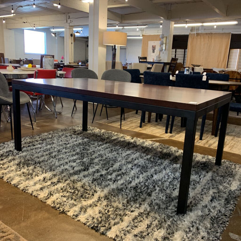 Long wooden table in a room with chairs and a rug