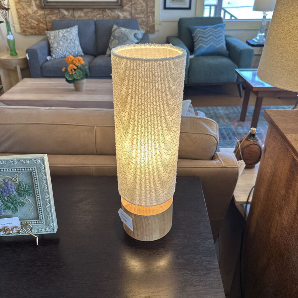 Decorative cylindrical lamp on a table in a living room setting