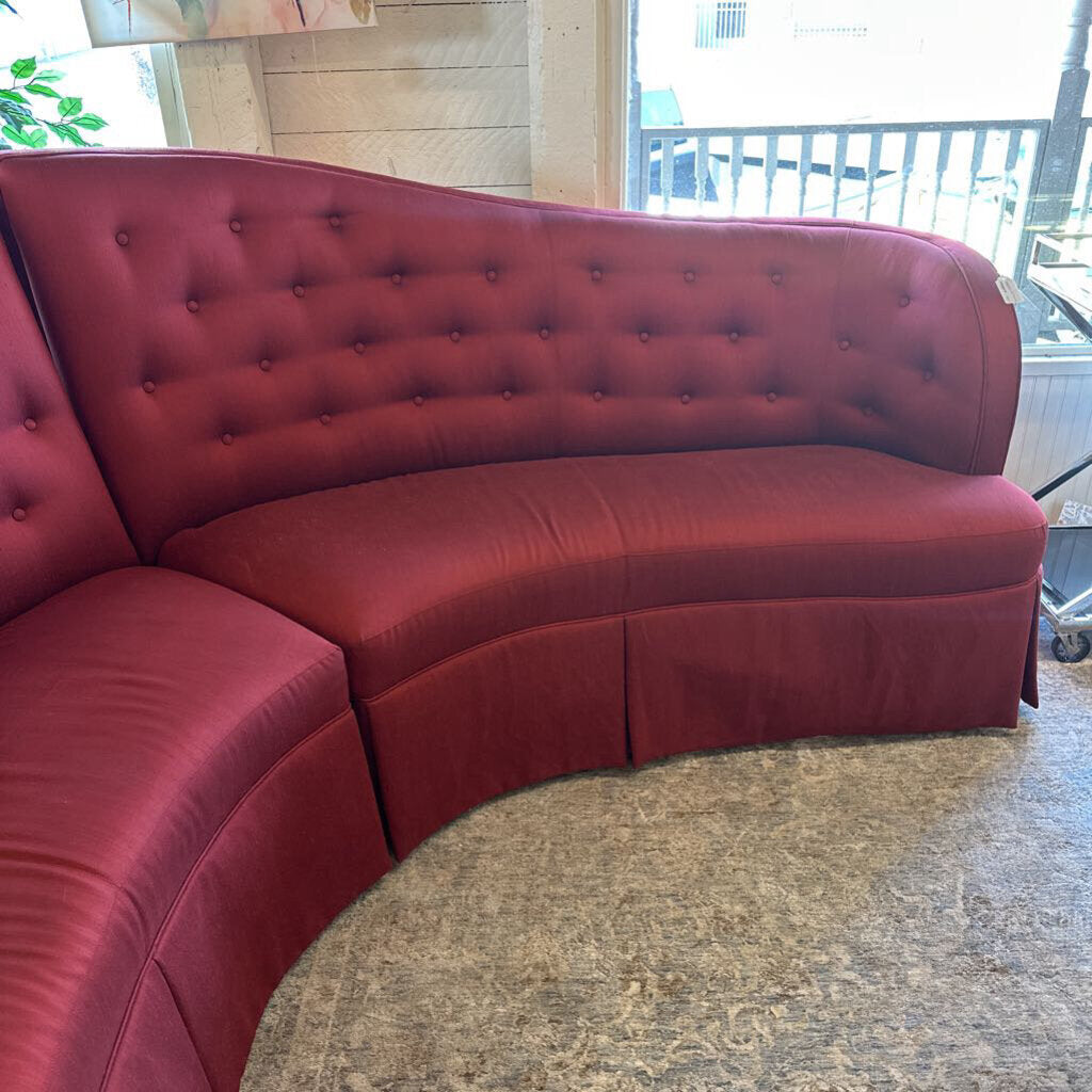 Red curved sofa in an indoor setting with a neutral background