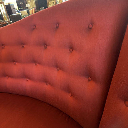 Close-up of a red tufted headboard with button details.