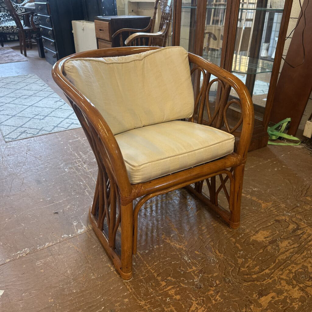 Wicker chair with beige cushions on a wooden floor