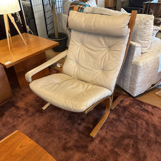 Beige armchair with wooden frame in a room setting