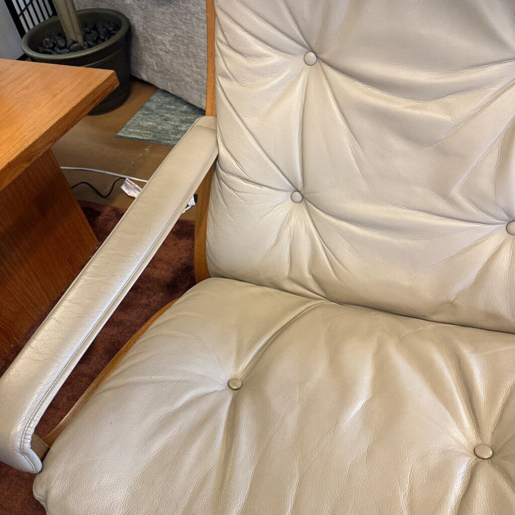 Beige recliner chair in a home setting with wooden furniture and a rug.