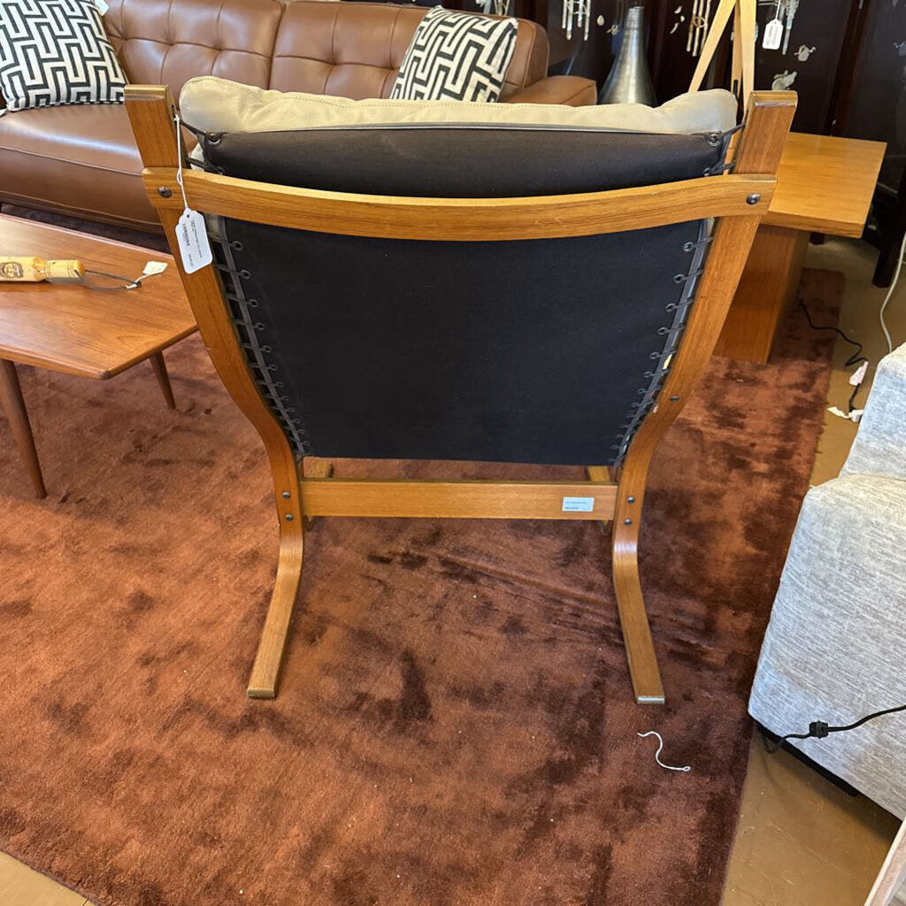 Wooden chair with black cushion in a furniture store setting