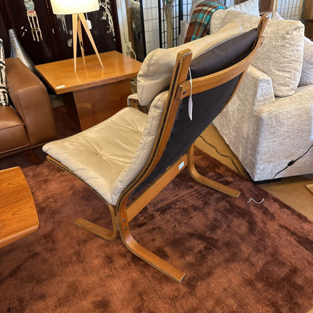 Wooden chair with beige cushion in a room with furniture and decor.